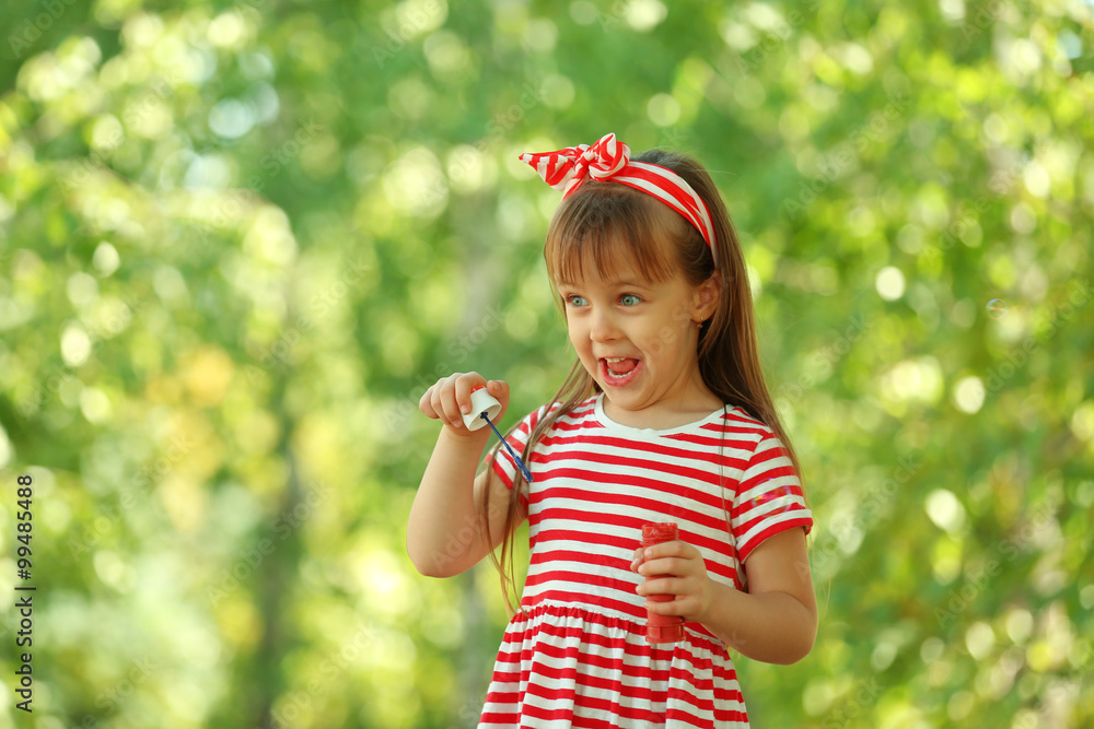 Little girl playing with bubbles in the park Little girl playing with bubbles in the park