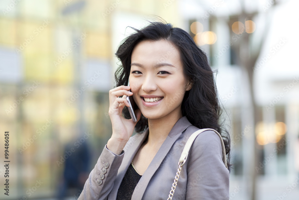 Cheerful young woman talking on the phone in city Cheerful young woman talking on the phone in city