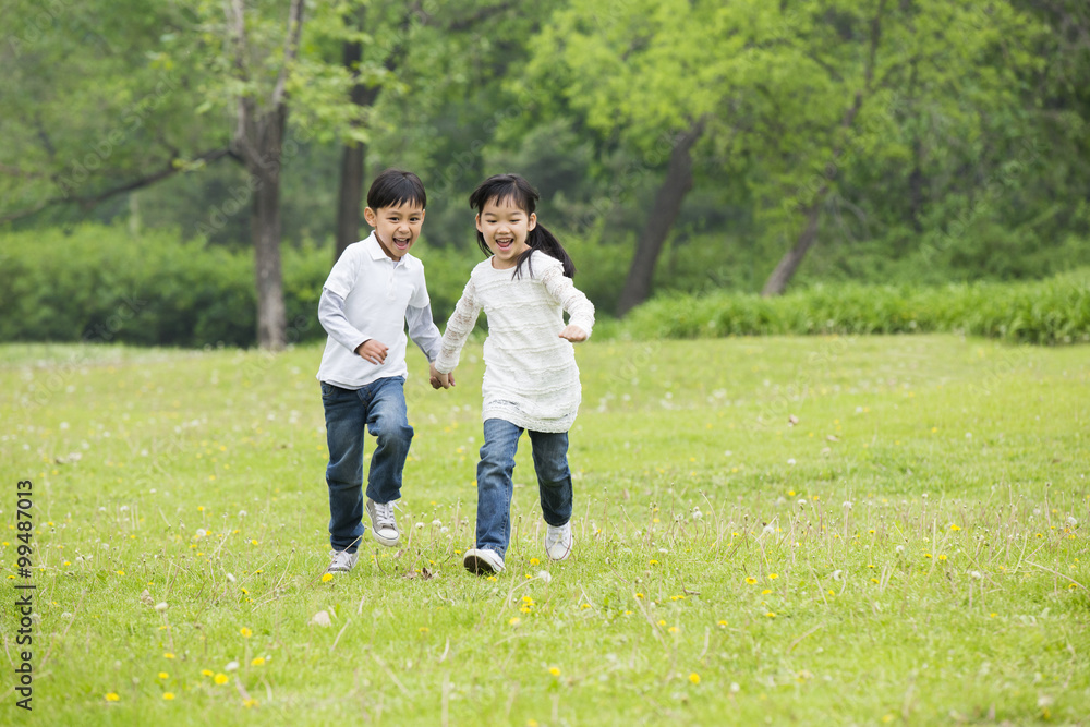 Happy children holding hands running on the grass Happy children holding hands running on the grass