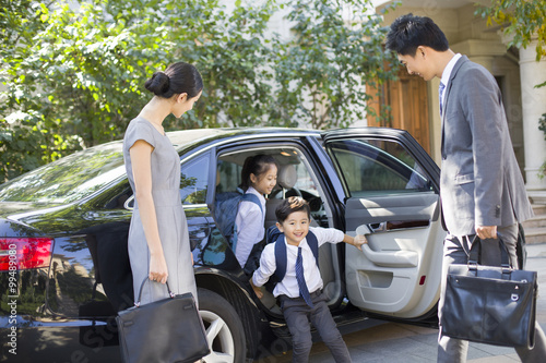 Young couple bringing their children back from school