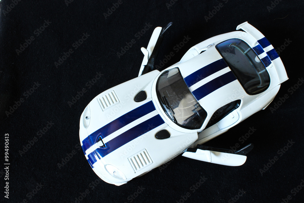 Fototapeta premium White Toy Car on the Black Background
