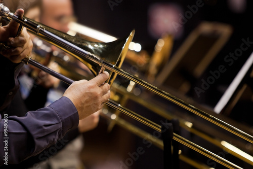 Hands of man playing the trombone in the orchestra