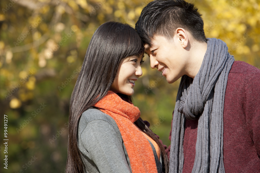 Fototapeta premium Sweet young couple in love face to face outdoors in autumn
