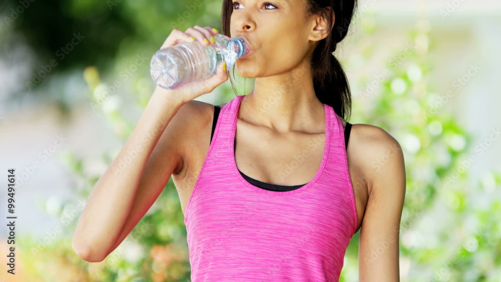 Young active African American woman drinking water and working up outdoor Young active African American woman drinking water and working up outdoor
