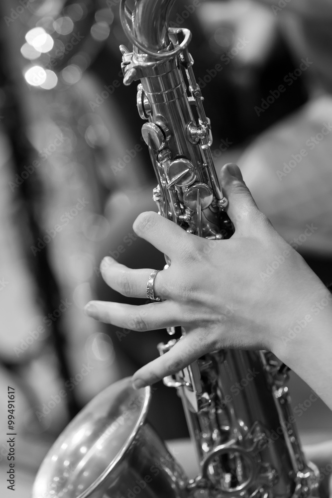 Obraz premium Hand girl playing the saxophone in black and white 