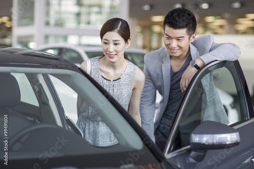 Young couple looking at new car in showroom © Blue Jean Images