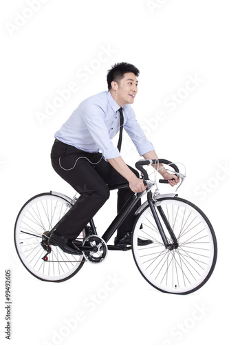 Cheerful young businessman riding a bike