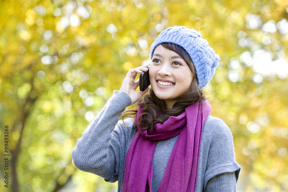 Young Woman Talking on a Mobile Phone in a Park Young Woman Talking on a Mobile Phone in a Park