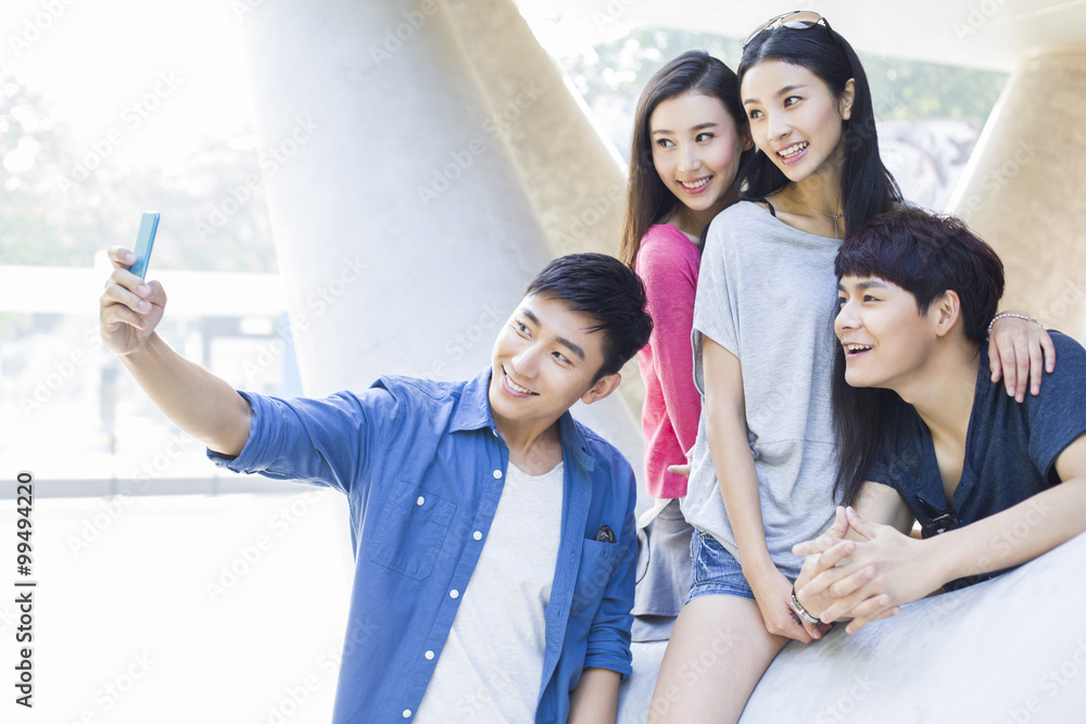 Obraz premium Young friends taking self portrait with a smart phone