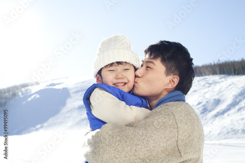 Father playing with son in snow
