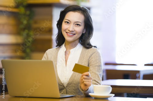 Young woman shopping online in cafe