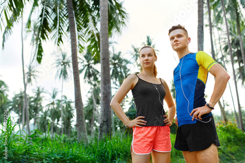 Healthy Lifestyle. Sporty Runner Couple Standing And Choosing Route For Running. Fit Athlete Male Jogger And Athletic Woman Preparing To Jog On Road. Fitness And Sports