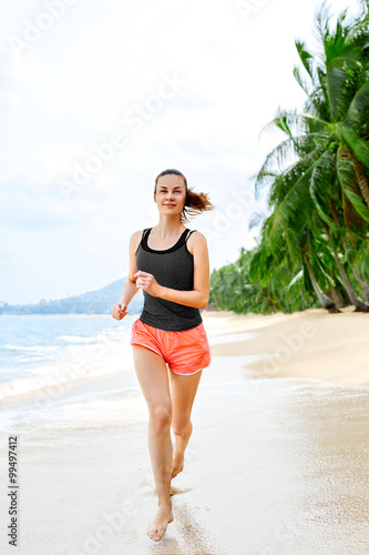 Fitness. Sporty Young Female Runner Running On Beach. Athletic Fit Woman Jogging During Workout Outside. Sports, Exercising, Healthy Lifestyle. Health Concept