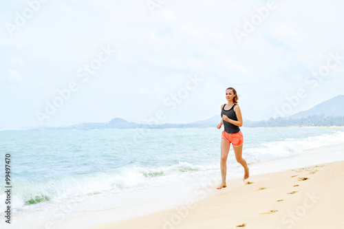 Sports. Fit Female Athlete Jogger Running On Beach. Sporty Athletic Woman Jogging During Workout Outside. Fitness, Exercising, Healthy Lifestyle. Health Concept © puhhha