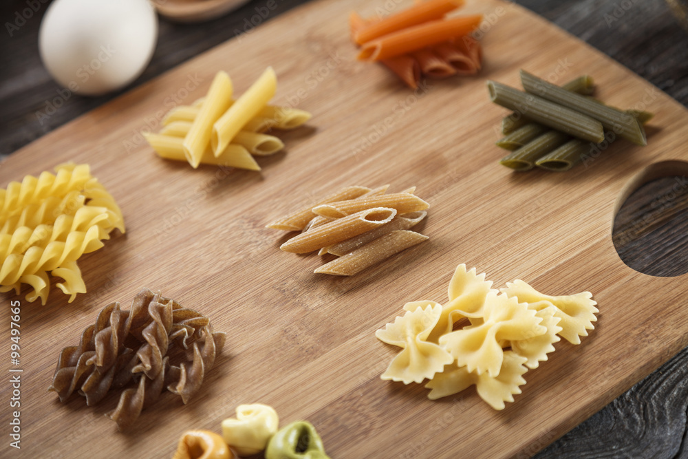 A set of raw pasta on a wooden desk A set of raw pasta on a wooden desk