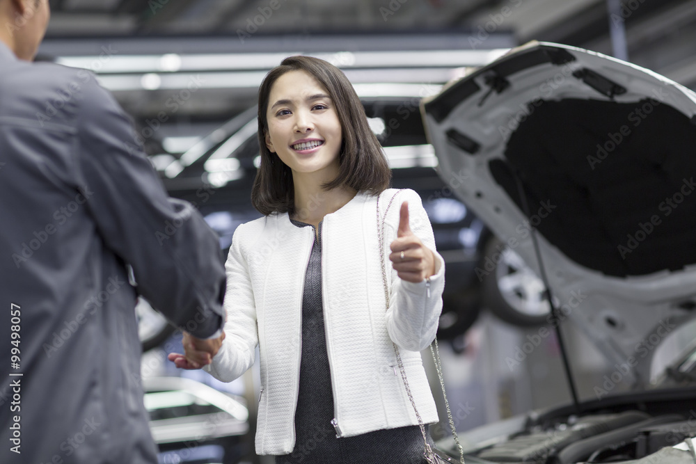 Auto mechanic and car owner shaking hands Auto mechanic and car owner shaking hands