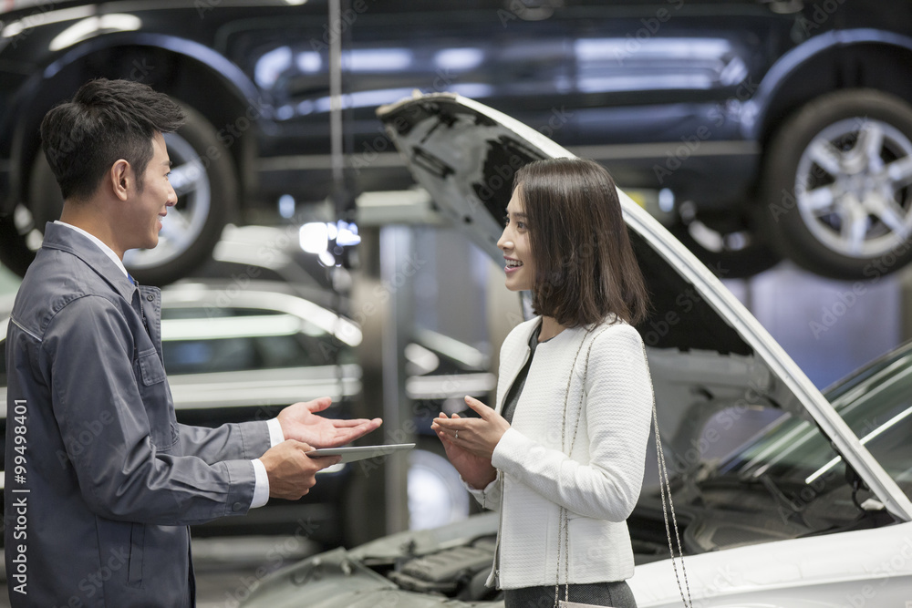 Auto mechanic talking with car owner Auto mechanic talking with car owner
