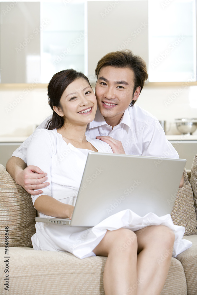 Young couple using a laptop at home Young couple using a laptop at home
