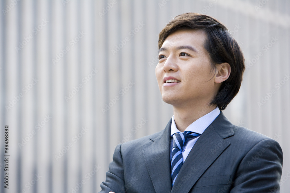 Confident businessman standing in front of downtown building Confident businessman standing in front of downtown building