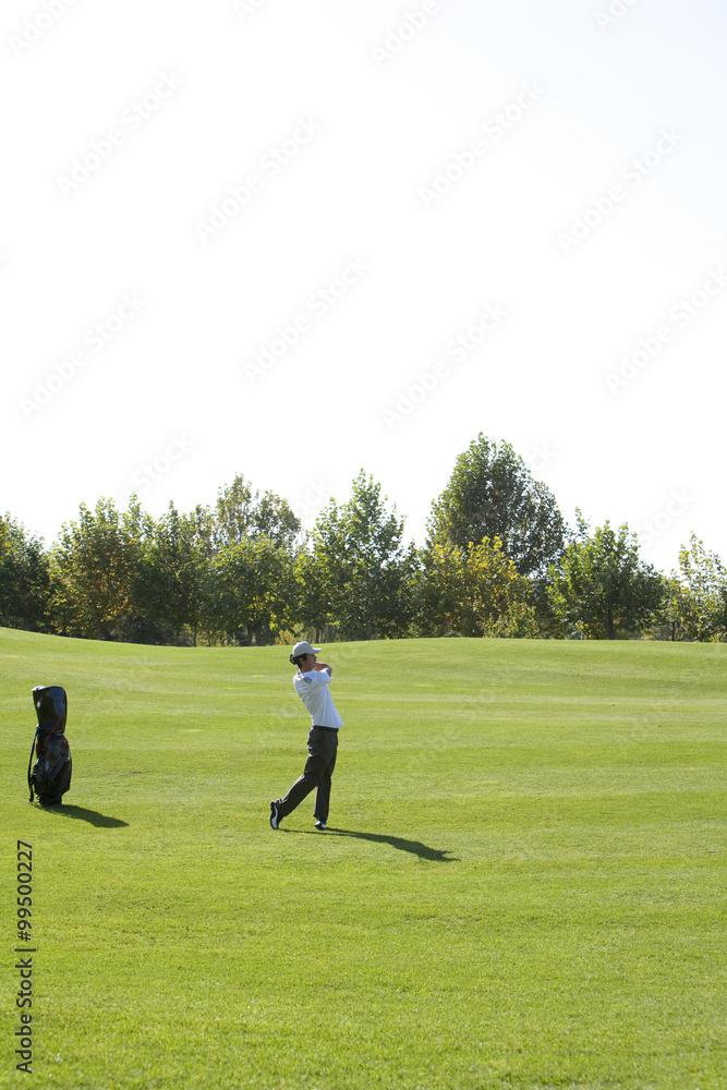 Young Man Taking a Golf Swing