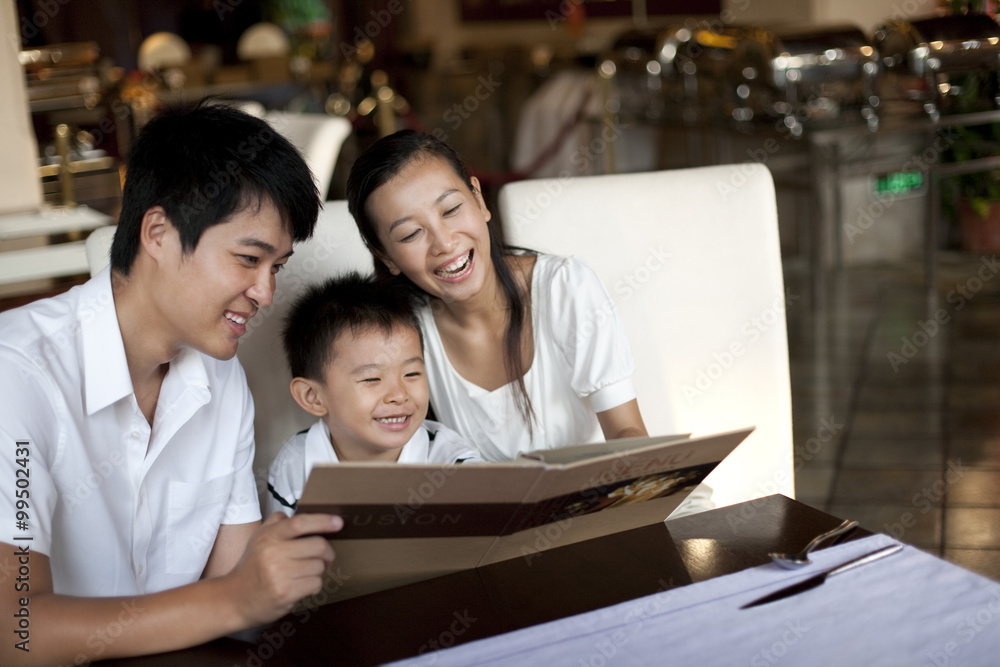 Portrait of a happy family looking through a menu Portrait of a happy family looking through a menu