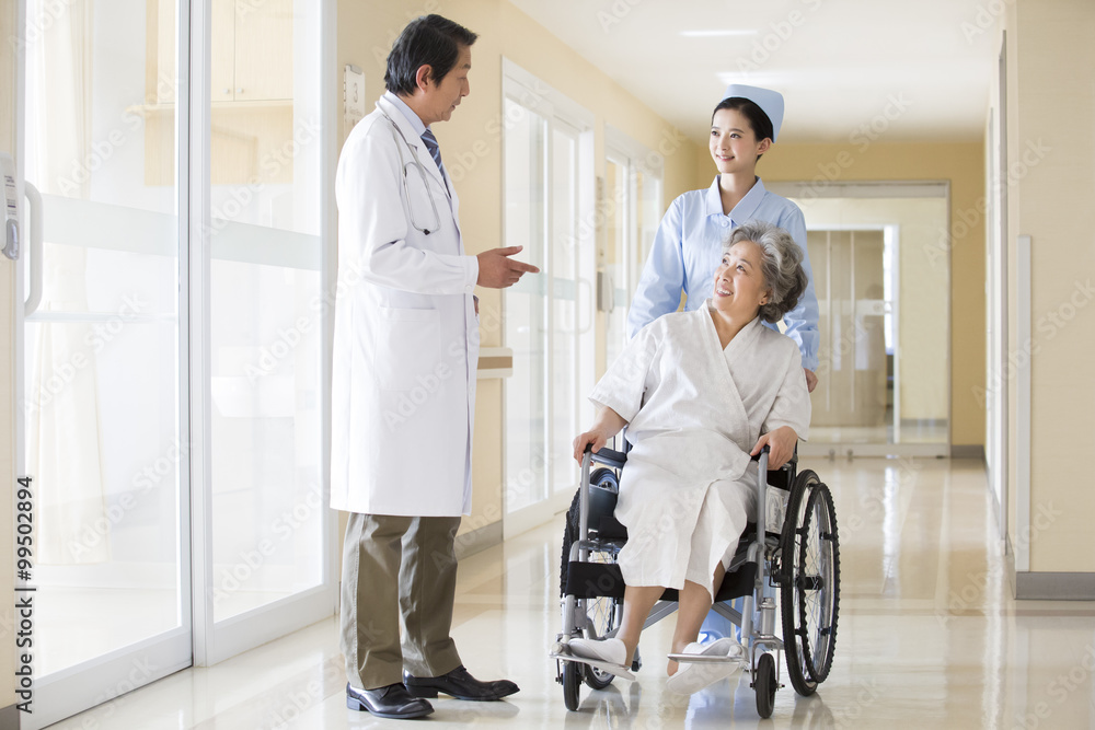 Obraz premium Medical workers taking care of senior woman in wheel chair