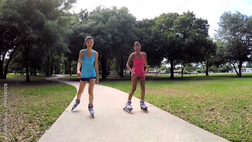 Young active multi ethnic American girls rollerblading outdoor