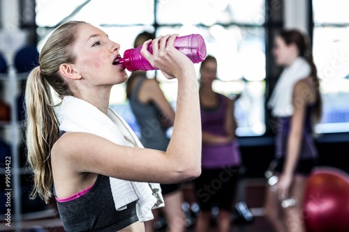 Blonde woman drinking water after working out 