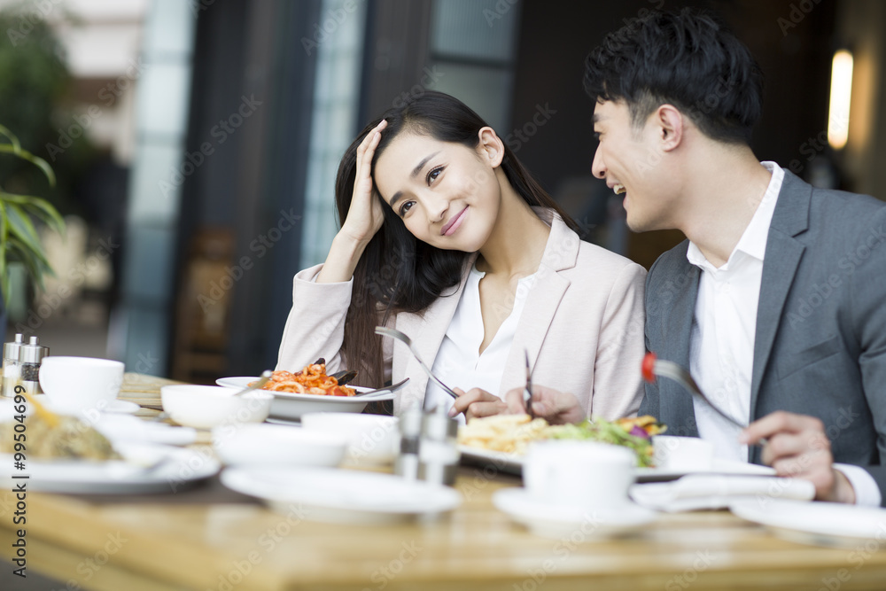 Smiling young couple dining in restaurant Smiling young couple dining in restaurant