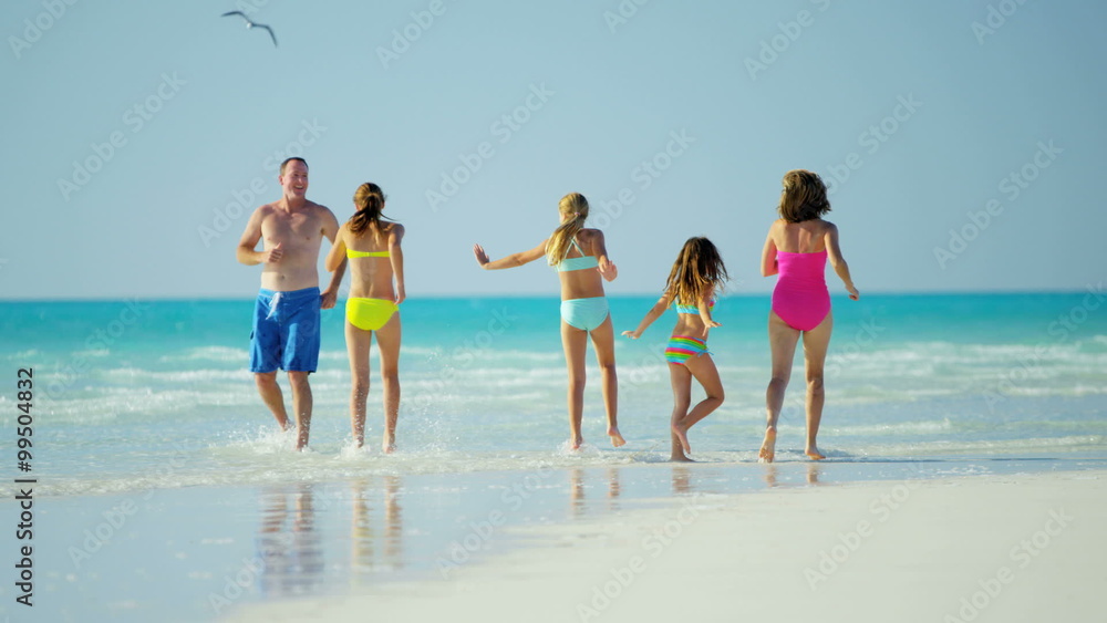 Healthy male female Caucasian family on tropical beach in swimwear Healthy male female Caucasian family on tropical beach in swimwear