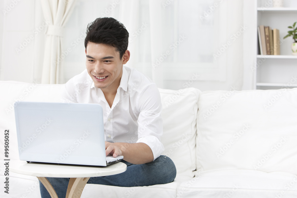 Young man using laptop at home Young man using laptop at home