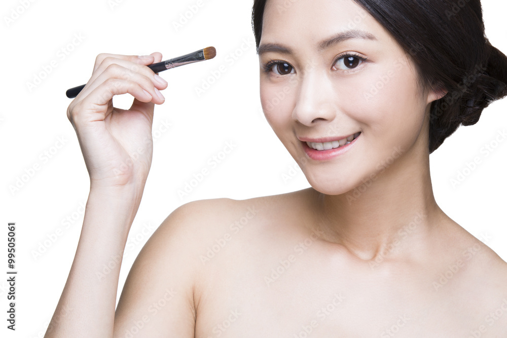 Beautiful young woman putting on make-up Beautiful young woman putting on make-up