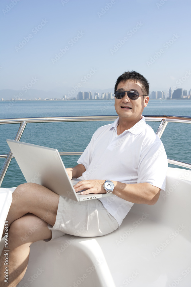 Man Using Laptop on Yacht