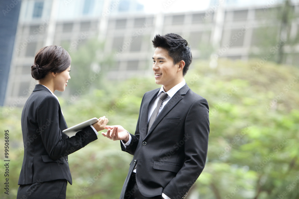 Cheerful business colleagues chatting with digital tablet in hand, Hong Kong Cheerful business colleagues chatting with digital tablet in hand, Hong Kong