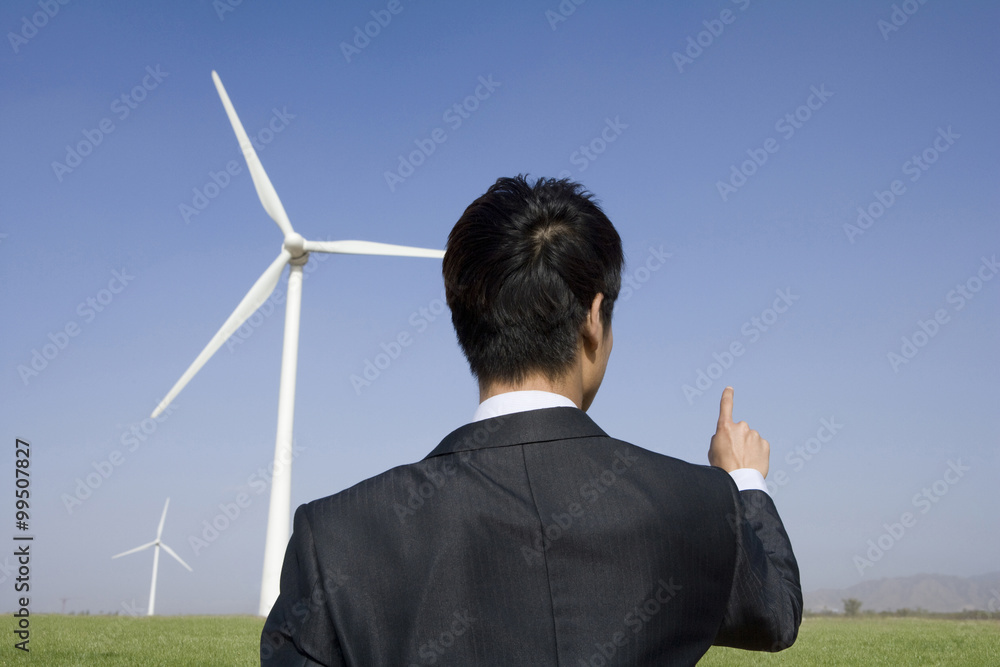 Businessman in front of wind turbine