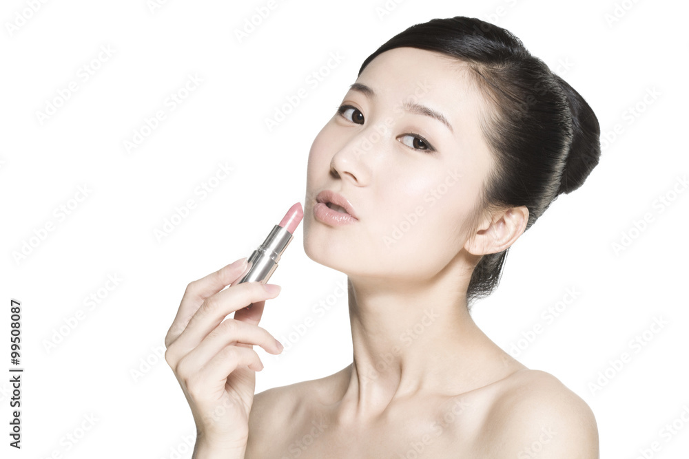 Beauty shot of a young woman applying lipstick Beauty shot of a young woman applying lipstick