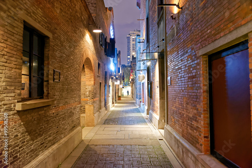 Empty street in the nigh with brick walls and warm light