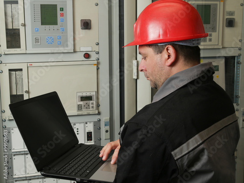  Technician with laptop in power plant