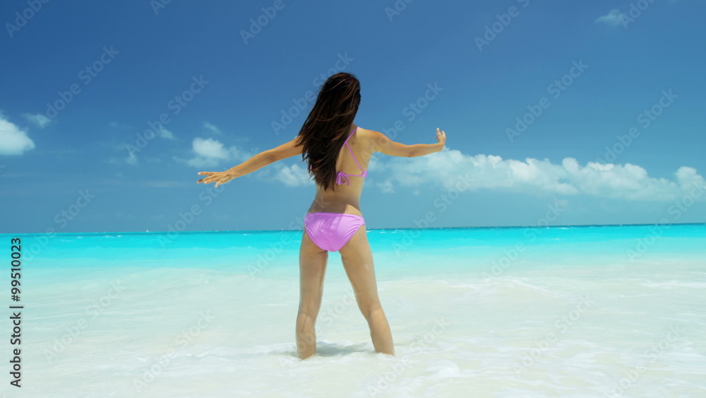 Ethnic Asian Chinese female white sand beach wearing bikini in ocean shallows Ethnic Asian Chinese female white sand beach wearing bikini in ocean shallows