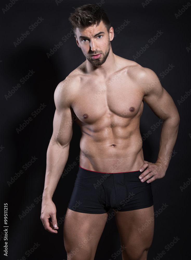 handsome young bodybuilder with toned body posing shirtless