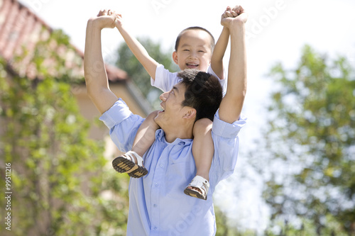 Father carrying son on shoulder