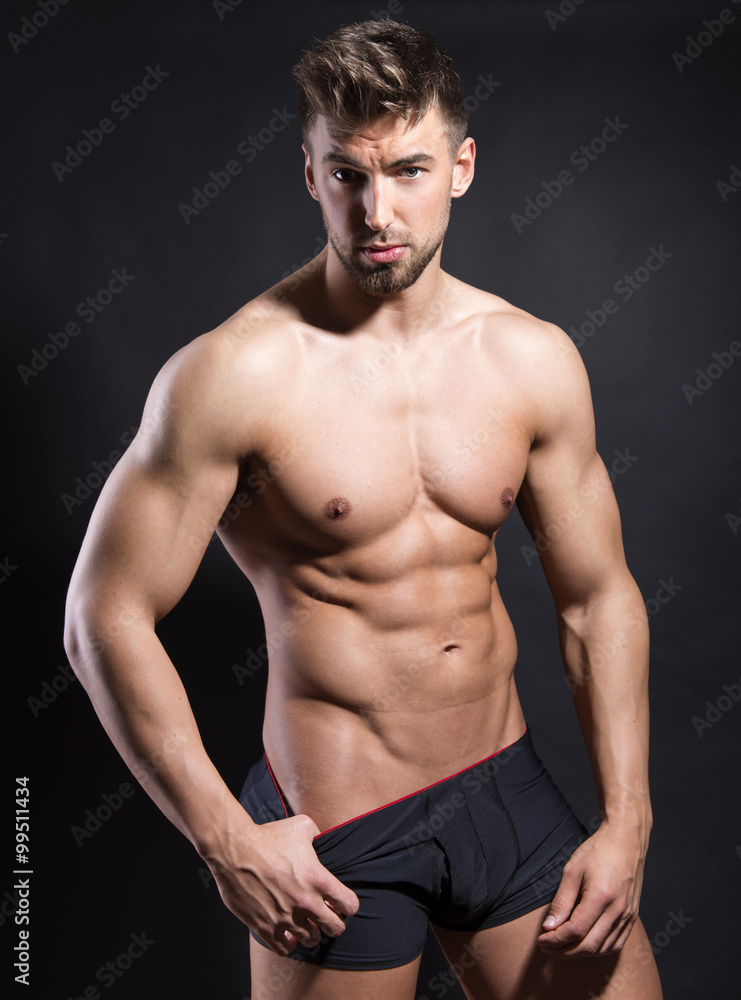 Fototapeta premium handsome young bodybuilder with toned body posing shirtless