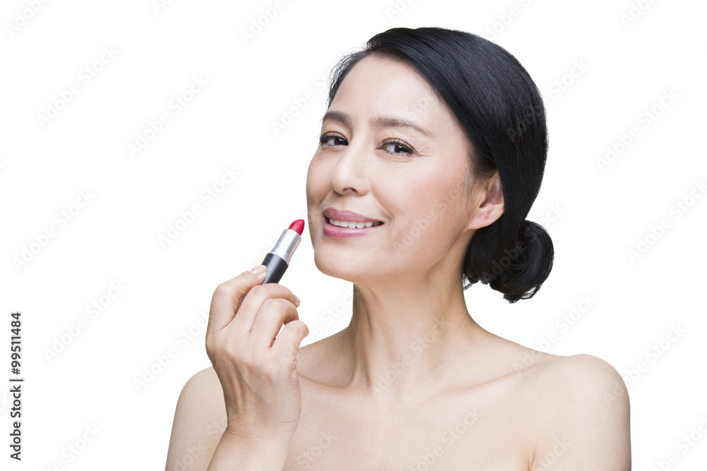 Beautiful mature woman applying lipstick Beautiful mature woman applying lipstick