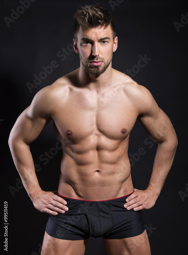 handsome young bodybuilder with toned body posing shirtless