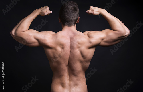 handsome young bodybuilder with toned body posing shirtless