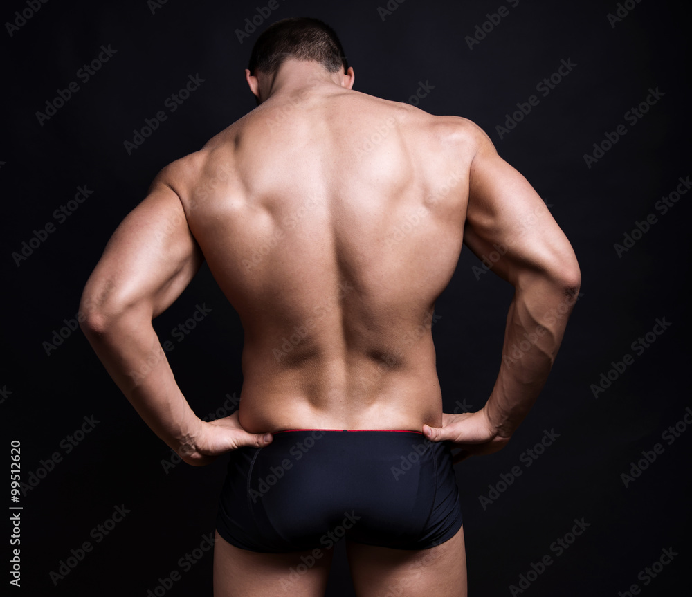 Fototapeta premium handsome young bodybuilder with toned body posing shirtless