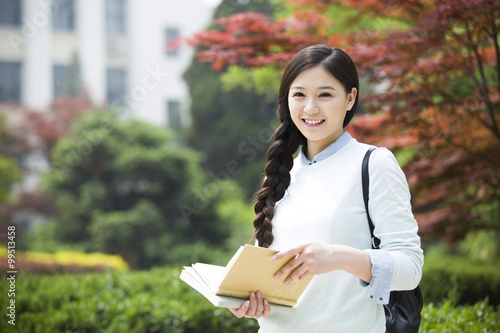 Female college student reading on campus photo