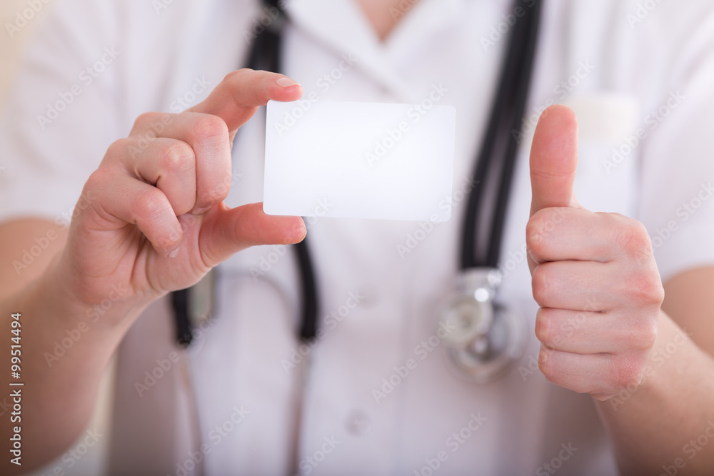 Female doctor showing business card and thumb up Female doctor showing business card and thumb up