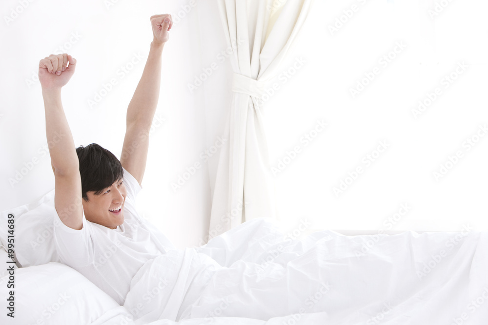 Young man giving a stretch in bed Young man giving a stretch in bed