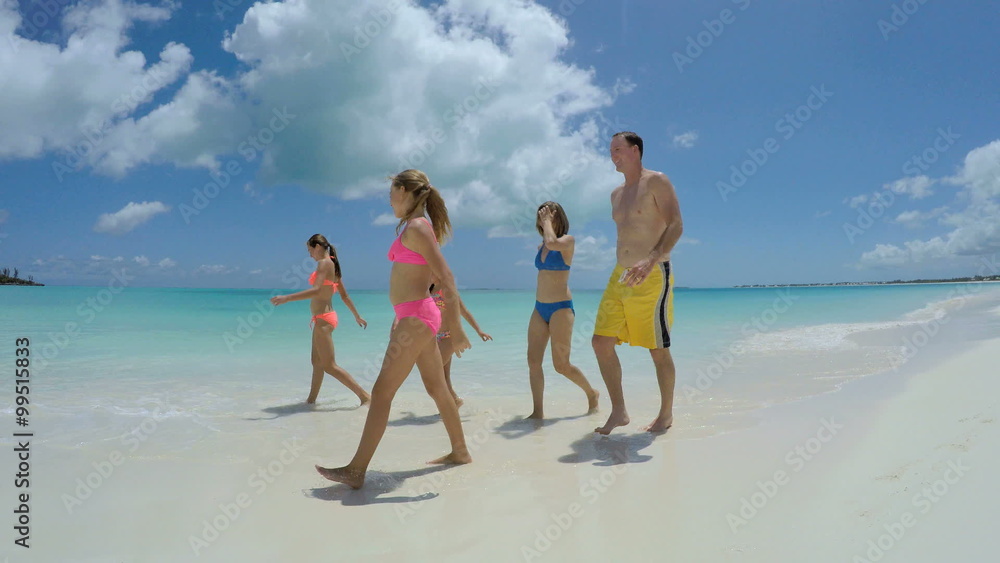 Smiling Caucasian family in swimwear walking barefoot Smiling Caucasian family in swimwear walking barefoot